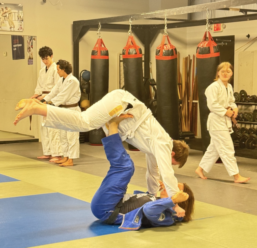 Adult martial arts participants kicking pads during stress-relief workout session